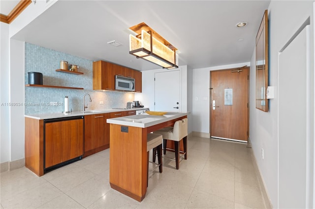 kitchen featuring tasteful backsplash, light tile flooring, paneled dishwasher, a kitchen island, and sink