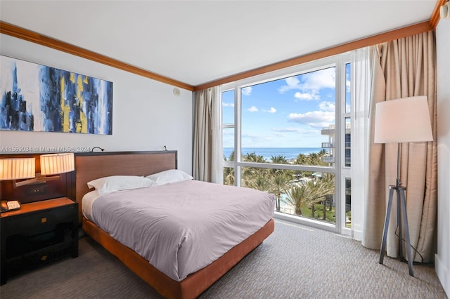 bedroom with multiple windows, dark carpet, a water view, and ornamental molding