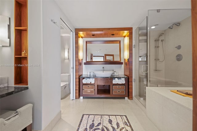 bathroom with tile flooring, vanity, toilet, and a shower with door