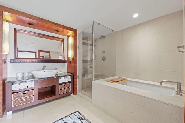 bathroom featuring tile flooring, independent shower and bath, tile walls, and large vanity