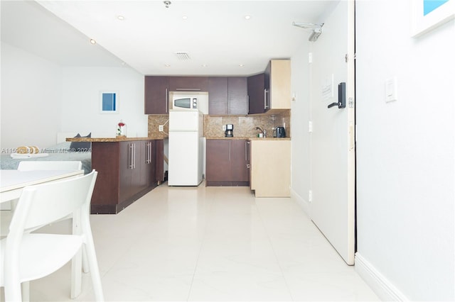 kitchen featuring dark brown cabinets, white appliances, and light tile flooring