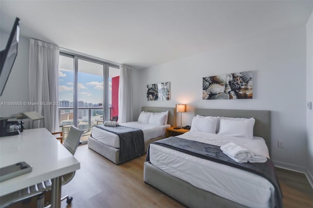 bedroom featuring hardwood / wood-style floors and expansive windows