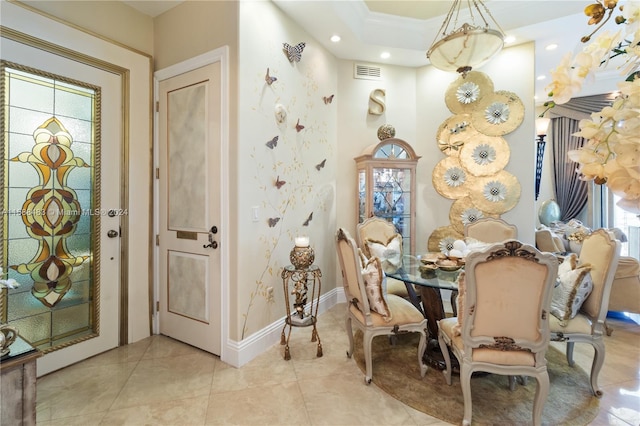 tiled dining space featuring plenty of natural light and a tray ceiling