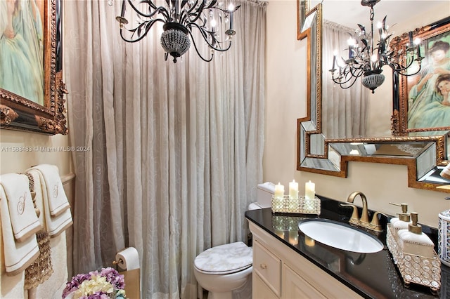 bathroom featuring a notable chandelier, toilet, and vanity