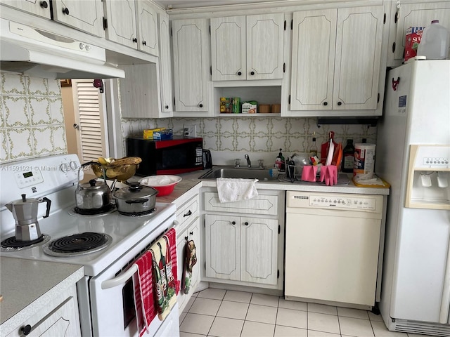 kitchen featuring sink, tasteful backsplash, white appliances, and light tile floors