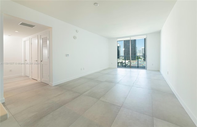 tiled spare room featuring expansive windows