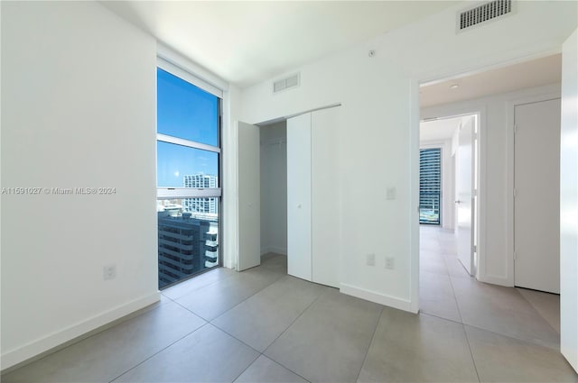 empty room with tile patterned flooring and floor to ceiling windows