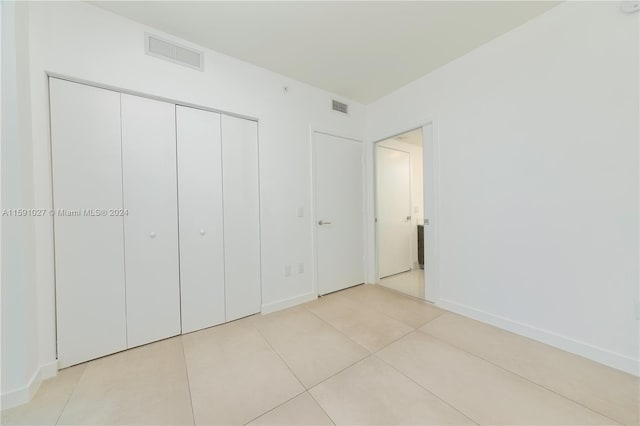 unfurnished bedroom featuring a closet and light tile patterned floors