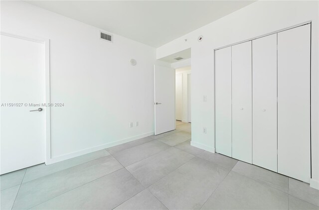 unfurnished bedroom featuring a closet and light tile patterned floors