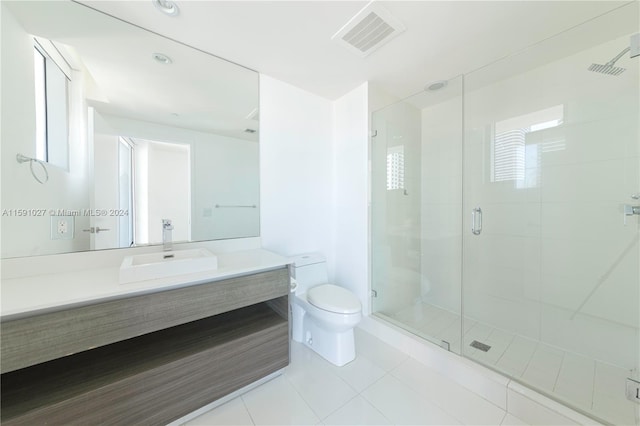 bathroom featuring vanity, walk in shower, tile patterned flooring, and toilet