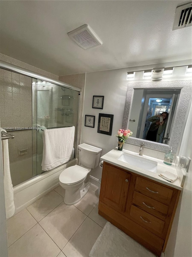 full bathroom with vanity, toilet, enclosed tub / shower combo, and tile patterned flooring