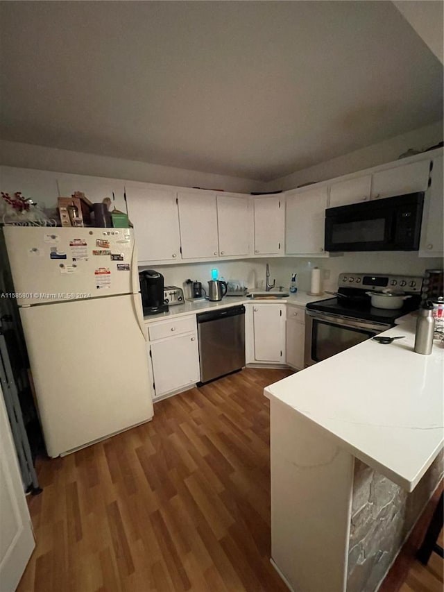 kitchen featuring kitchen peninsula, white cabinets, dark wood-type flooring, sink, and stainless steel appliances