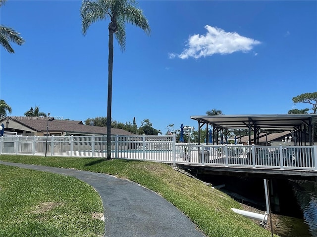 dock area featuring a pool side deck with water view and a yard