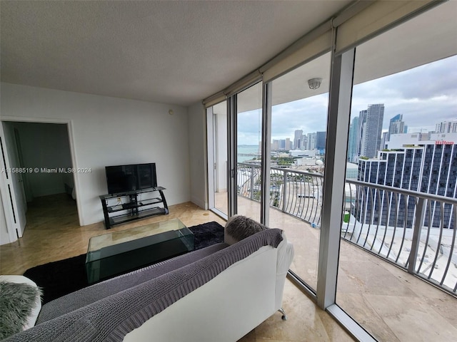 living room featuring a textured ceiling and a wall of windows