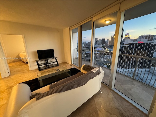 living room with tile flooring and a wall of windows