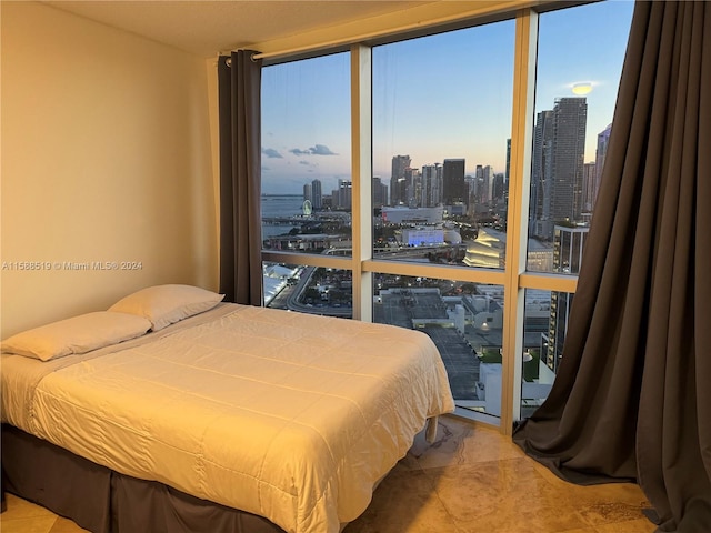 bedroom featuring tile floors and a wall of windows