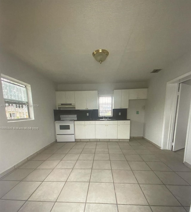 kitchen featuring white cabinetry, electric range, light tile patterned floors, and ventilation hood