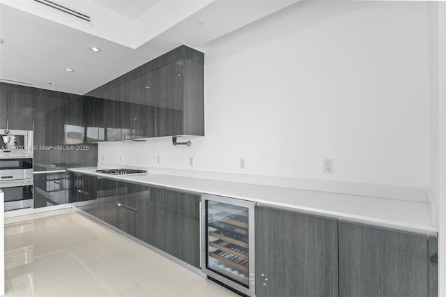 kitchen with recessed lighting, modern cabinets, wine cooler, gas cooktop, and light countertops
