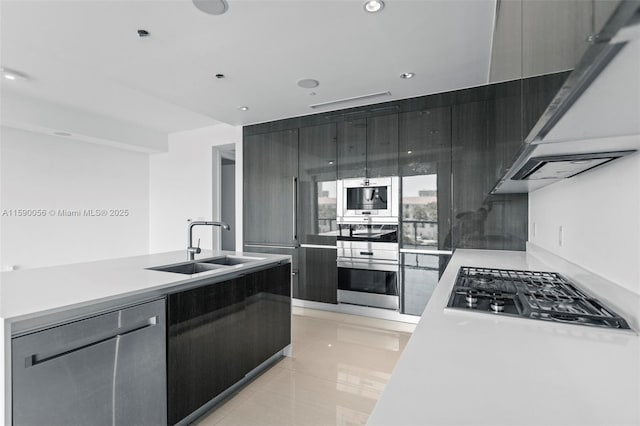 kitchen featuring modern cabinets, a sink, appliances with stainless steel finishes, and under cabinet range hood