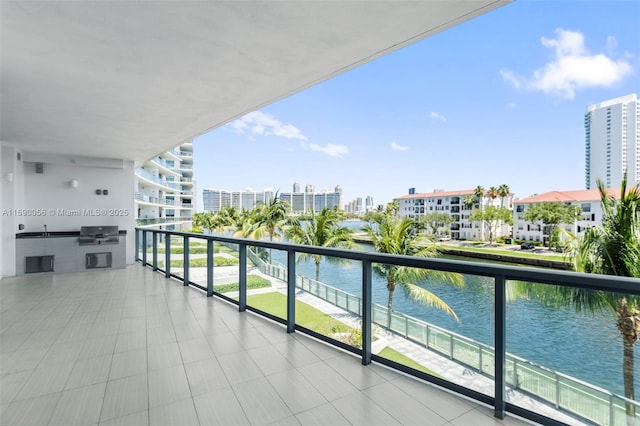 balcony featuring area for grilling, grilling area, and a water view