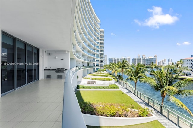 surrounding community with a water view and a lawn