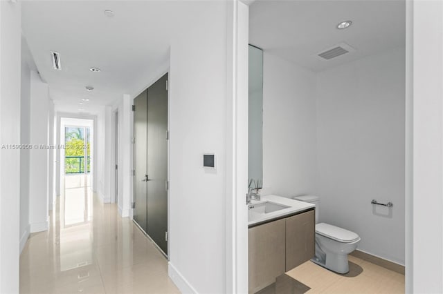 bathroom with tile floors, vanity, and toilet