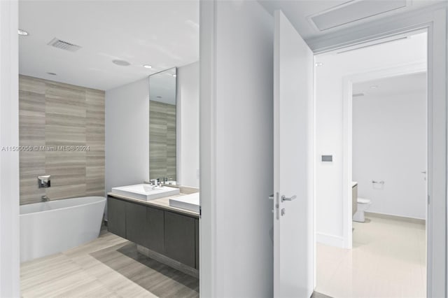 bathroom featuring tile flooring, vanity, toilet, and a bathtub