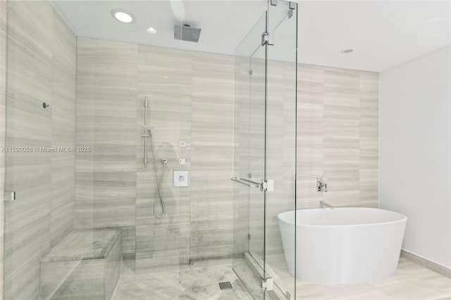 full bathroom with a freestanding tub, a shower stall, and recessed lighting