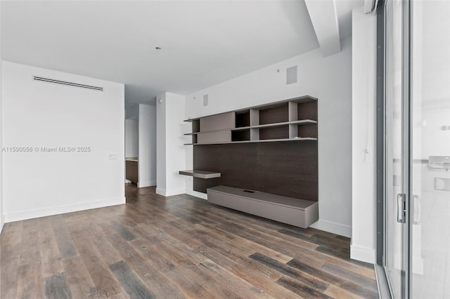 unfurnished living room featuring visible vents, dark wood-style flooring, and baseboards