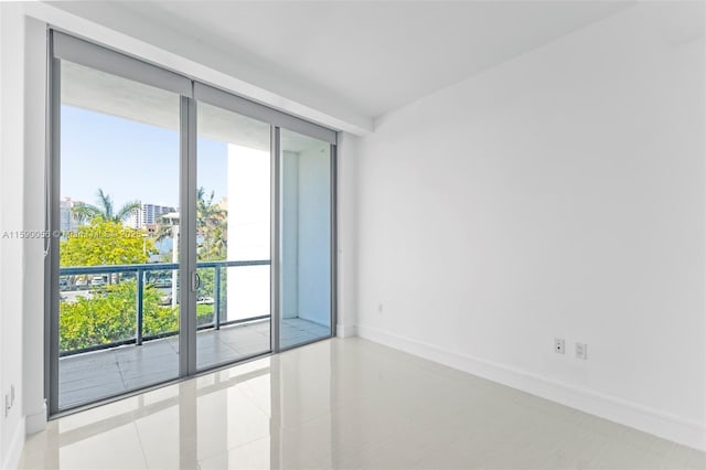 unfurnished room featuring tile patterned flooring, french doors, and baseboards