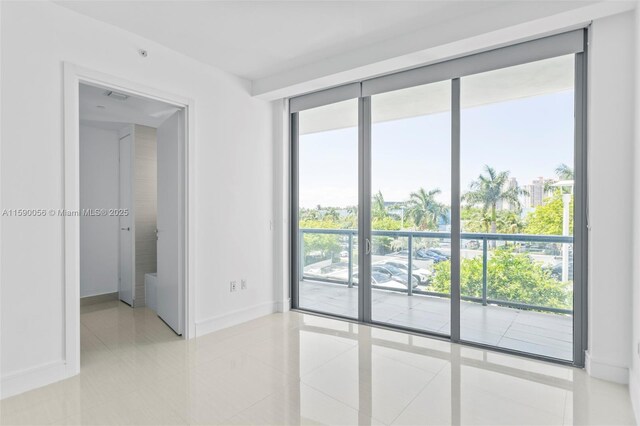 unfurnished room featuring light tile patterned flooring and baseboards