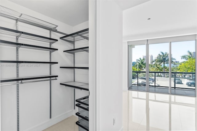 walk in closet with light tile floors