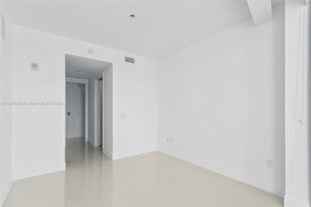 spare room featuring baseboards and visible vents