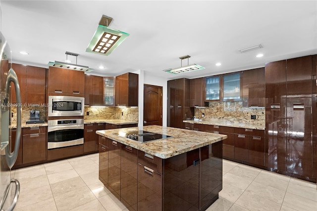 kitchen with a kitchen island, tasteful backsplash, appliances with stainless steel finishes, and light tile patterned floors