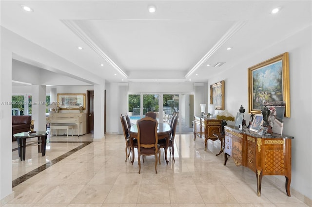 dining room with a raised ceiling and crown molding