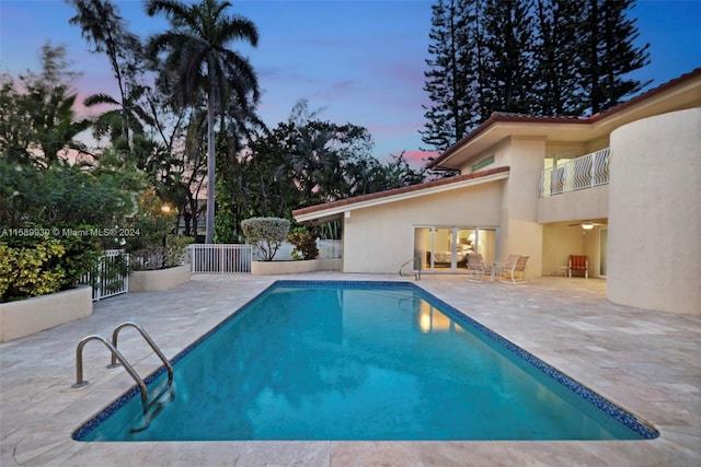 pool at dusk with a patio