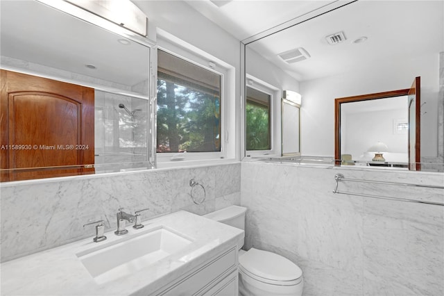 bathroom featuring vanity, tile walls, an enclosed shower, and toilet