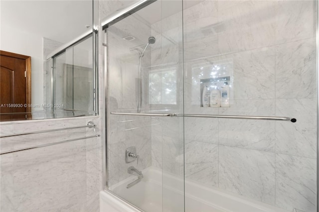 bathroom featuring combined bath / shower with glass door