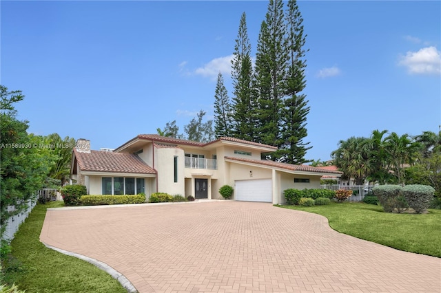 mediterranean / spanish home with a garage and a front lawn