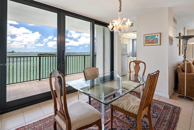 tiled dining area with expansive windows, plenty of natural light, and an inviting chandelier