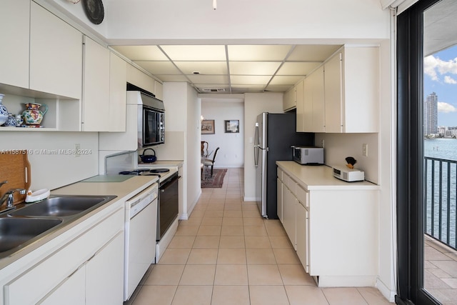 kitchen featuring light tile patterned flooring, sink, white cabinets, and appliances with stainless steel finishes