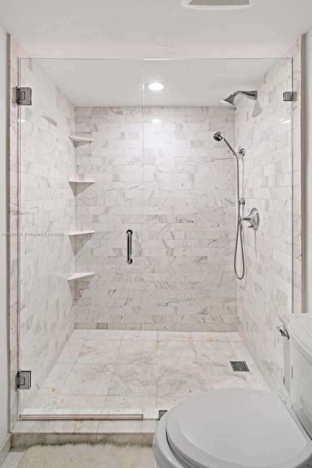 bathroom featuring an enclosed shower and toilet