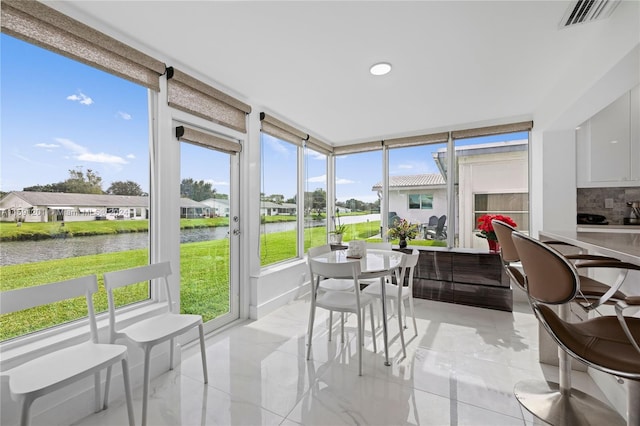 sunroom / solarium with a water view