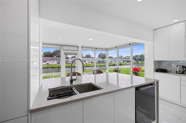 kitchen with sink, light stone counters, decorative backsplash, light tile patterned floors, and white cabinets