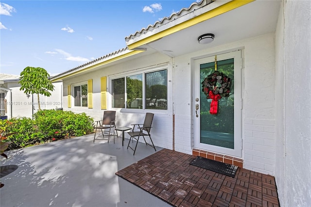 view of exterior entry featuring a patio