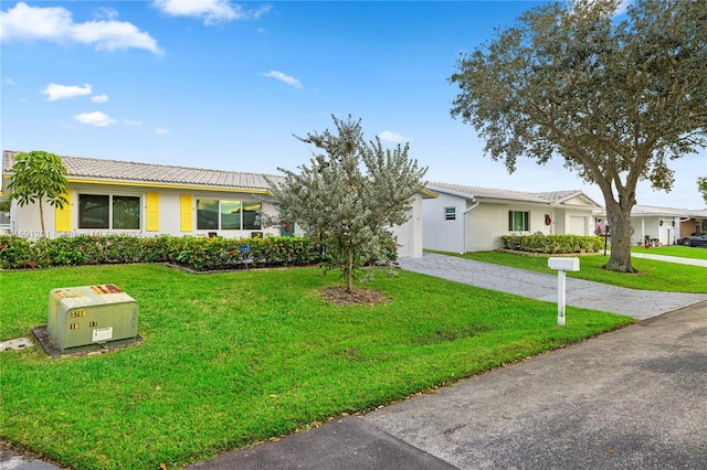 ranch-style house featuring a garage and a front lawn