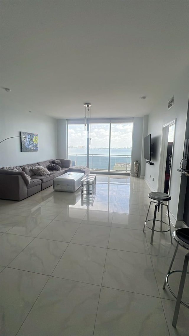 tiled living room with a wall of windows