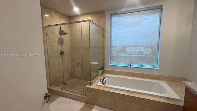 bathroom featuring tile flooring, independent shower and bath, and vanity