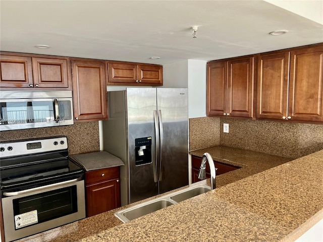 kitchen featuring light stone countertops, backsplash, and appliances with stainless steel finishes