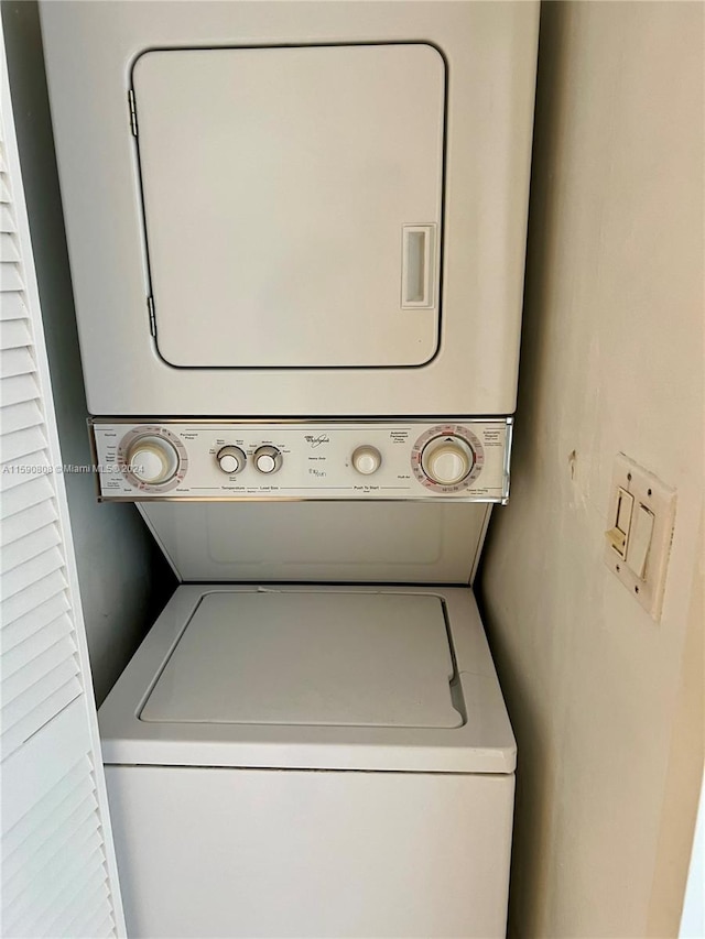 clothes washing area featuring stacked washer and clothes dryer